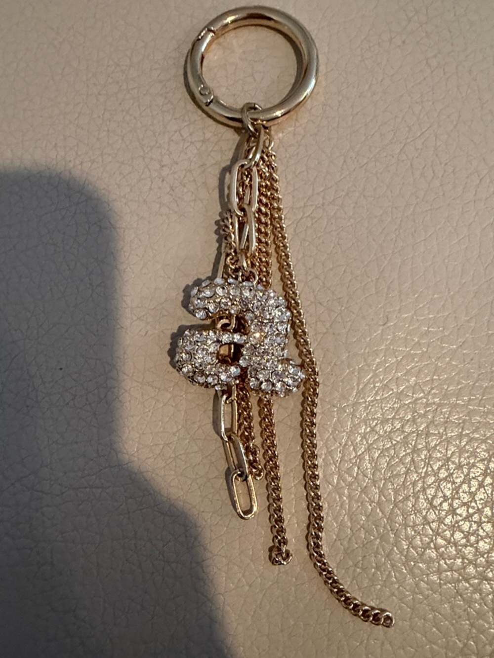 A Gold-Tone Crystal Keychain Charm - Interlocking Double Design
